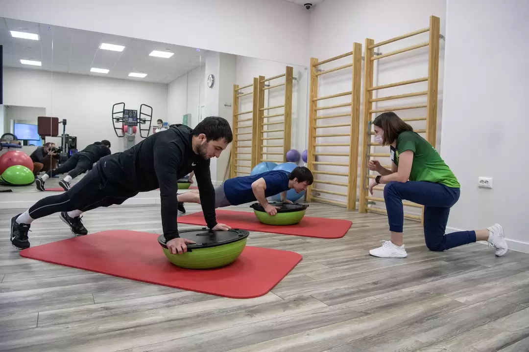 A rehabilitation therapist conducts exercise therapy classes with patients suffering from low back pain